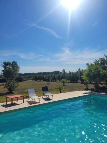 - une piscine avec 2 chaises, une table et un banc dans l'établissement Villa provençale à Arles avec piscine privée et vue jardin., à Arles