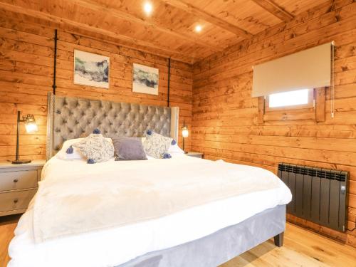 a bedroom with a large bed in a wooden wall at Chicken Run in Oakham