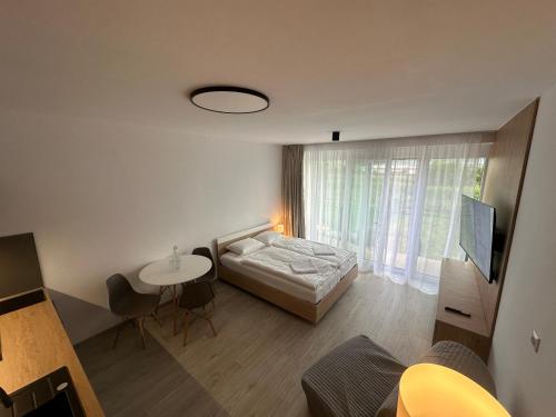 a bedroom with a bed and a table and a television at Apartmán na Liptove in Liptovský Mikuláš