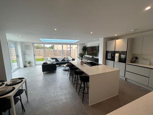 a kitchen and living room with a counter and chairs at Luxury 4 bedroom house in Bristol