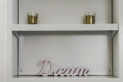 a shelf with two glasses and a sign on it at Spacieux appart terrasse métro hôpital 4pers wifi in Villejuif