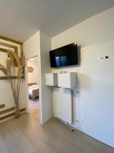 une pièce avec une télévision à écran plat sur un mur dans l'établissement Spacieux appart terrasse métro hôpital 4pers wifi, à Villejuif