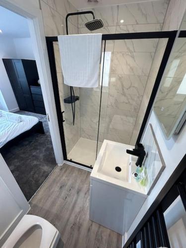 a bathroom with a shower and a white sink at Luxury 4 bedroom house in Bristol