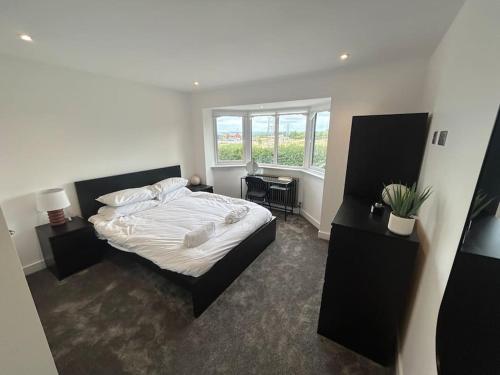 a bedroom with a white bed and a window at Luxury 4 bedroom house in Bristol