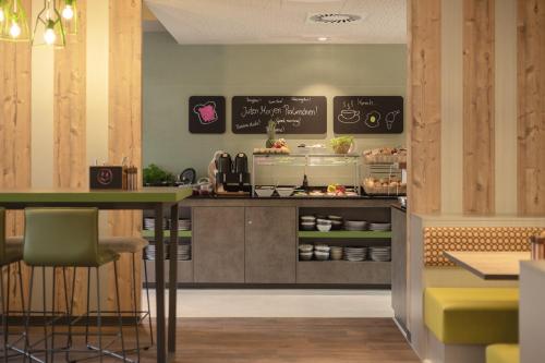 a restaurant with a counter with aasteryasteryasteryasteryasteryasteryasteryasteryastery at Holiday Inn - the niu, Mill Cologne Mülheim by IHG in Cologne