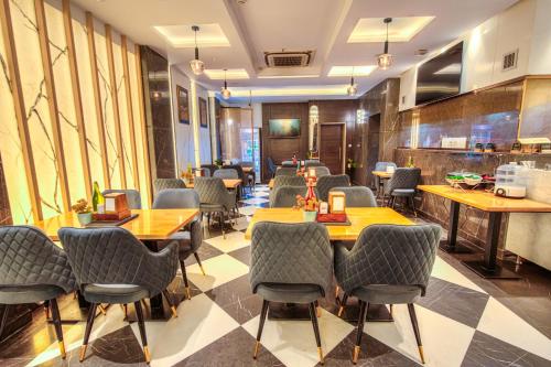 Un restaurante con mesas y sillas en una habitación. en The Singh Empire,New Delhi, en Nueva Delhi