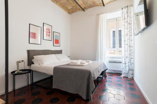 ein weißes Schlafzimmer mit einem Bett und einem Fenster in der Unterkunft Half Palace, relaxing apartment in Rome San Lorenzo in Rom