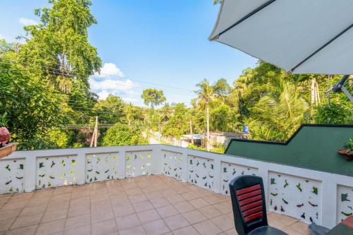 a balcony with a chair and trees in the background at Villa Wedamulla in Unawatuna