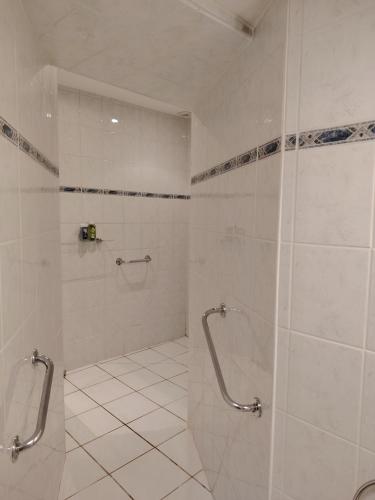 une salle de bain carrelée blanche avec une douche à l'italienne dans l'établissement Belle maison spacieuse près d'Arbois, à Mesnay