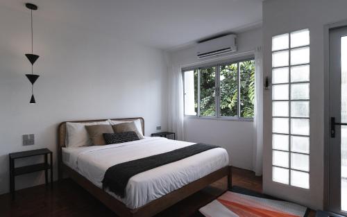 a bedroom with a bed and a window at Flat and Fur 2BR Mid-Century 3mins to Nimman Airport in Chiang Mai