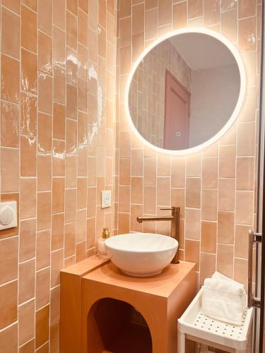 une salle de bain avec un lavabo et un miroir dans l'établissement Colisee, à Paris