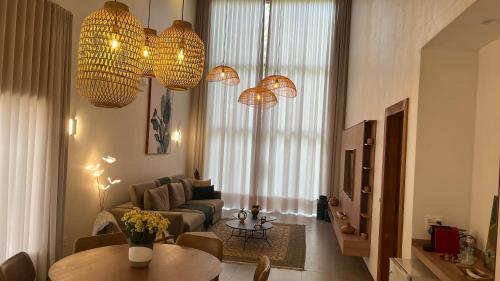 a living room with a couch and a table and chandeliers at Pousada Cavaleiro dos Pireneus in Pirenópolis