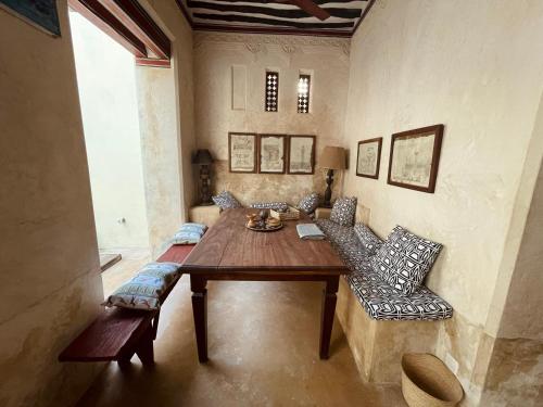 a dining room with a wooden table and chairs at Umma House in Lamu