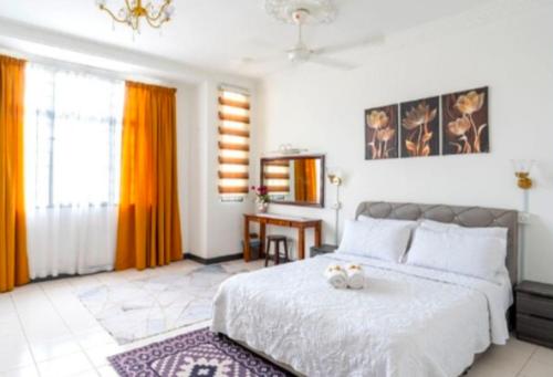a bedroom with a bed with two stuffed animals on it at Shah Alam Golden Homestay 4 Rooms, 3 Bathrooms Seksyen 7 near uitm icity in Shah Alam