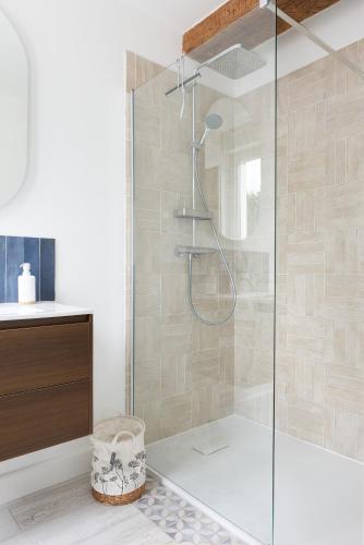 une douche avec une porte vitrée dans une salle de bain dans l'établissement Appartement de l'UNESCO de Blaye - Proche centre ville & citadelle - Lumineux et Spacieux, à Blaye