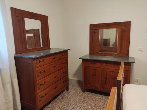 a bedroom with two wooden dressers and a mirror at Lunamora 2 in Rodi Garganico