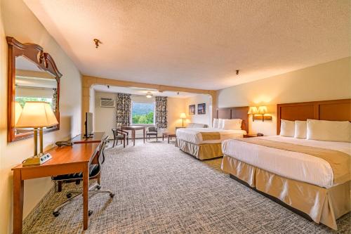 a hotel room with two beds and a desk at Town & Country Inn & Resort in Gorham