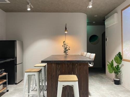 a kitchen with a counter with stools and a table at Marin Base ONAHAMA in Iwaki