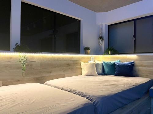two beds in a room with two windows at Marin Base ONAHAMA in Iwaki