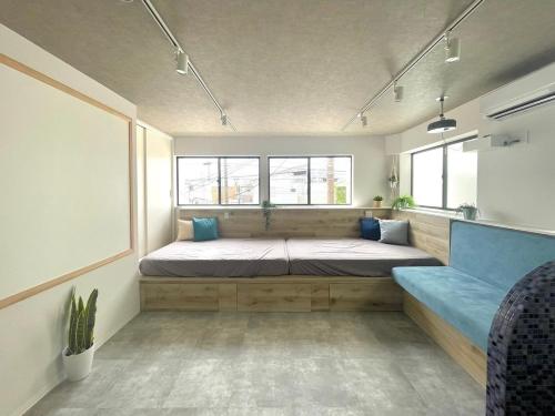 a bedroom with a large bed and a blue couch at Marin Base ONAHAMA in Iwaki