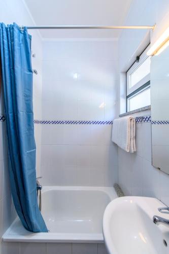 a white bathroom with a tub and a sink at Afonso's House Gerês I in Braga