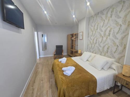 a bedroom with a large bed with towels on it at Lugo Apartamento nuevo en centro de la ciudad in Lugo