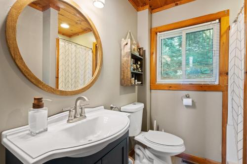 a bathroom with a sink and a mirror and a toilet at Belleau Lake Escape in Wakefield
