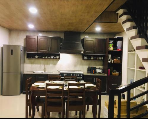 a kitchen with a table with chairs and a refrigerator at Mommy Mia Bed and Breakfast in Dasag