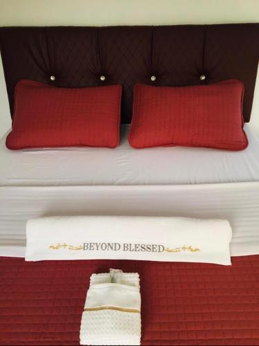 a bed with red pillows and a sign that says boyfriend blessed at Mommy Mia Bed and Breakfast in Dasag