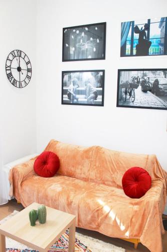 - un canapé avec des oreillers rouges dans le salon dans l'établissement Lofty - Massena sq - 5 min walk Beach, à Nice