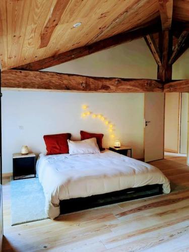 - une chambre avec un grand lit et des plafonds en bois dans l'établissement Aux sources de lesquire maison 5 chambres 5 salles de bains , 11 personnes, à Saugnacq-et-Muret