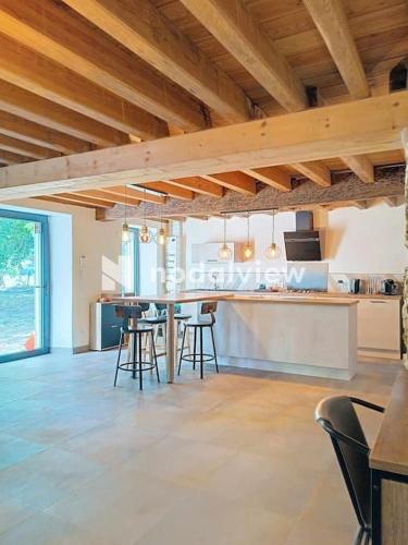 une cuisine avec une table et des chaises dans une pièce dans l'établissement Aux sources de lesquire maison 5 chambres 5 salles de bains , 11 personnes, à Saugnacq-et-Muret