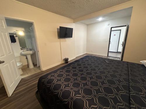 a hotel room with a bed and a sink at Budget Inn Hollywood in Los Angeles