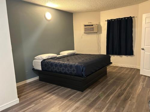 a small room with a bed and a window at Budget Inn Hollywood in Los Angeles