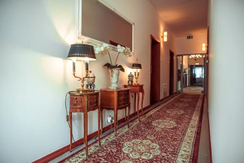a hallway with two lamps and a vase on a table at Hotel Maxim Kwidzyn in Kwidzyn