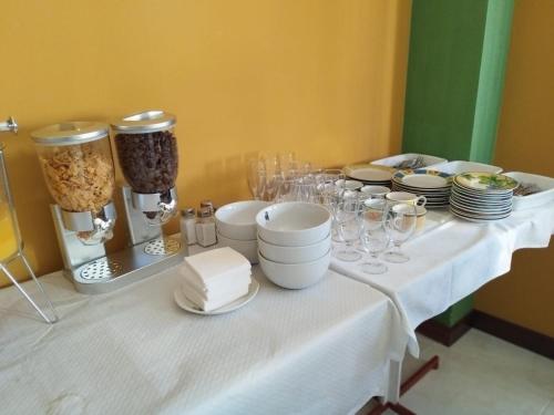 a white table with plates and glasses on it at Hotel Mataleñas in Santander