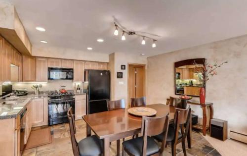 a kitchen and dining room with a table and chairs at Best location in the heart of lions head, Ski lockers, jacuzzi and pool in Vail