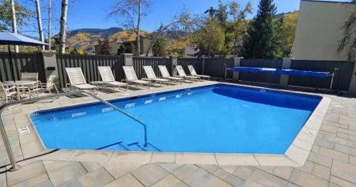 a large swimming pool with chairs at Best location in the heart of lions head, Ski lockers, jacuzzi and pool in Vail