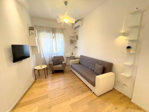 una sala de estar con un sofá y una silla en MilleStorie House Rome, en Roma