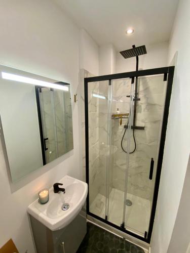 une salle de bain blanche avec une douche et un lavabo dans l'établissement Le Cordelier - Hypercentre - Quartier Historique, à Caen