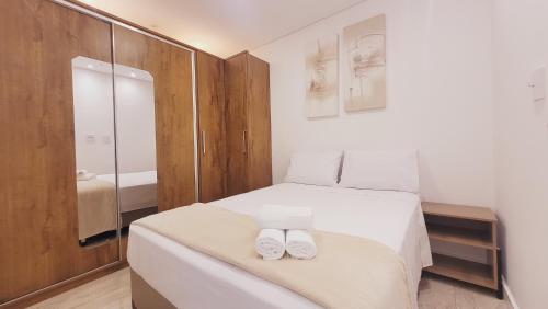 una camera da letto con un letto con due asciugamani sopra di O mais lindo 2 dorms no Unlimited Ocean Front 1312 a Santos