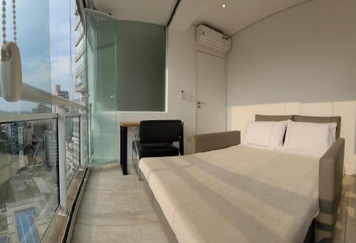una camera da letto con un letto, una scrivania e una finestra di O mais lindo 2 dorms no Unlimited Ocean Front 1312 a Santos