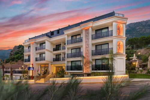 a white building with a sunset in the background at AMOSSİA Elite Boutique Hotel in Turunc