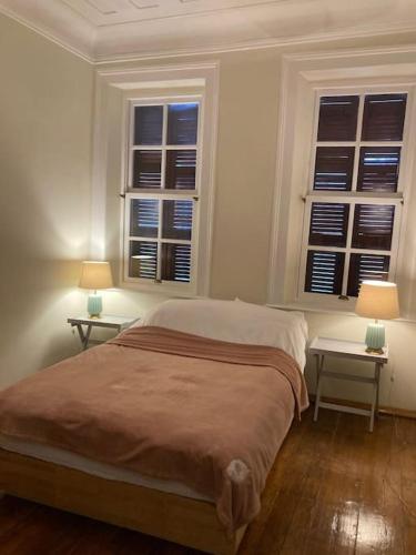 a bedroom with two tables and a bed with two windows at Maris Alsancak City Center in Konak