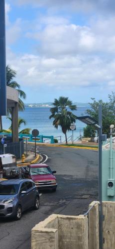 two cars parked in a parking lot next to the ocean at Sweet Sunset 4 Playa Rompeolas, Aguadilla in Aguadilla