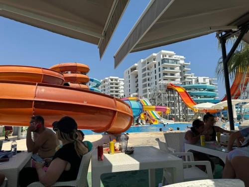 a group of people sitting at tables on the beach at Schönes Apartment mit Luxus-Design auf Nordzypern, in Caesar Resort Marcellus 52 in İskele