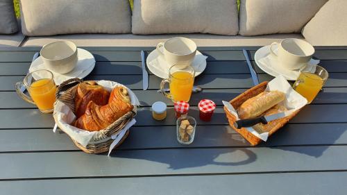 - une table de pique-nique avec du pain et des verres de jus d'orange dans l'établissement Au fil de l'eau, à La Chapelle-Saint-Aubin