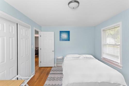 a white bedroom with a bed and a window at Charming 3-bedroom house in Wilmington with WiFi, AC in Wilmington
