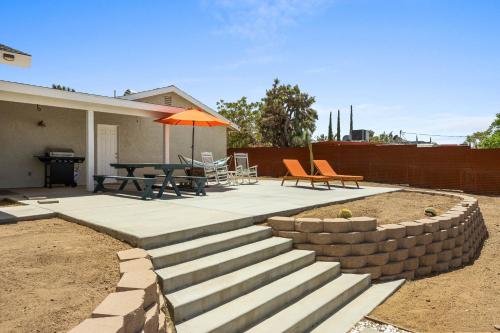 a patio with a table and chairs and an umbrella at Bonanza in the Desert - Pool, Hot Tub, Grill home in Yucca Valley
