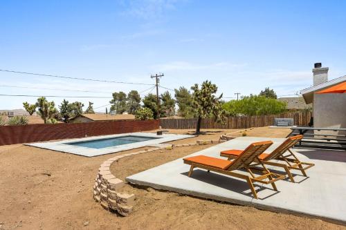 a patio with two lawn chairs and a pool at Bonanza in the Desert - Pool, Hot Tub, Grill home in Yucca Valley